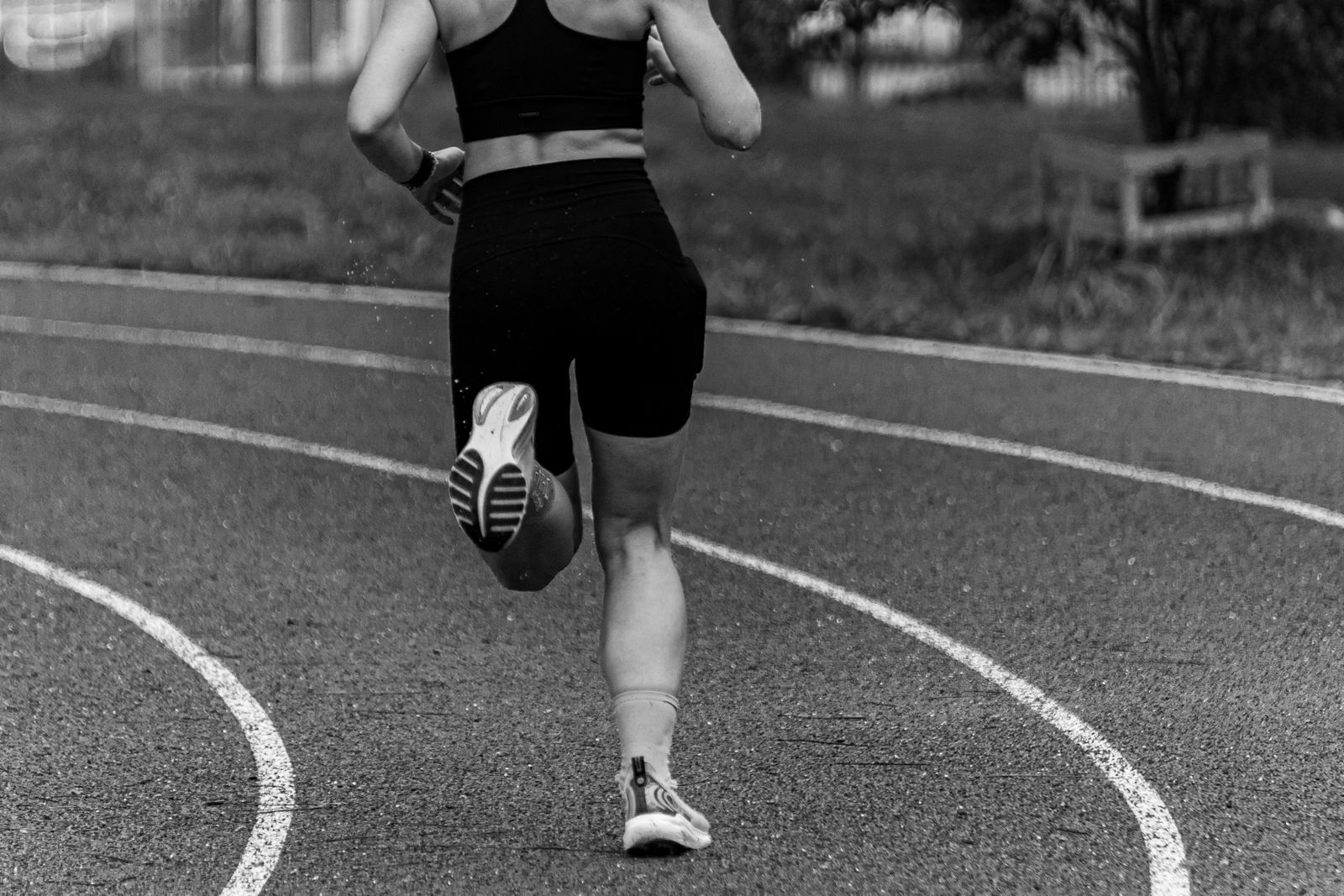 Close view of a runner moving around an outdoor track